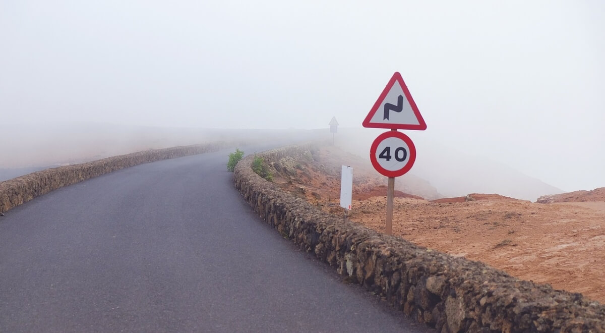 40 km/h Straßenschild auf nebel-verhüllter Serpentinen Straße