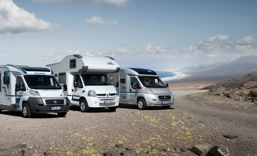 Alkove Kastenwagen und Campingbus Wohnmobiltypen geparkt an Küstenstreifen