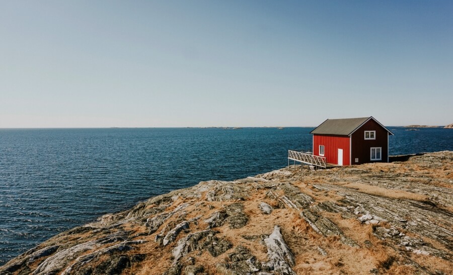 Schwedisches Holzhaus in Rot an Felsküste