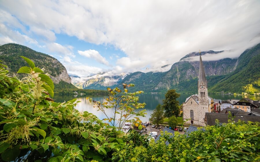 Österreichisches Dorf mit Kirchturm am See in der Natur