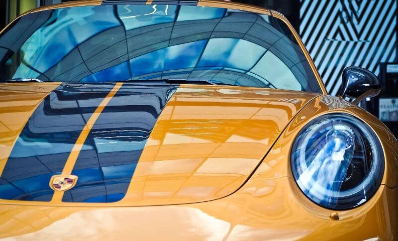 Gelber Porsche Boxster mit Rennstreifen von vorne