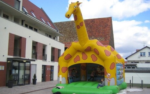 Giraffen Hüpfburg in Seitenansicht neben einem Gebäude