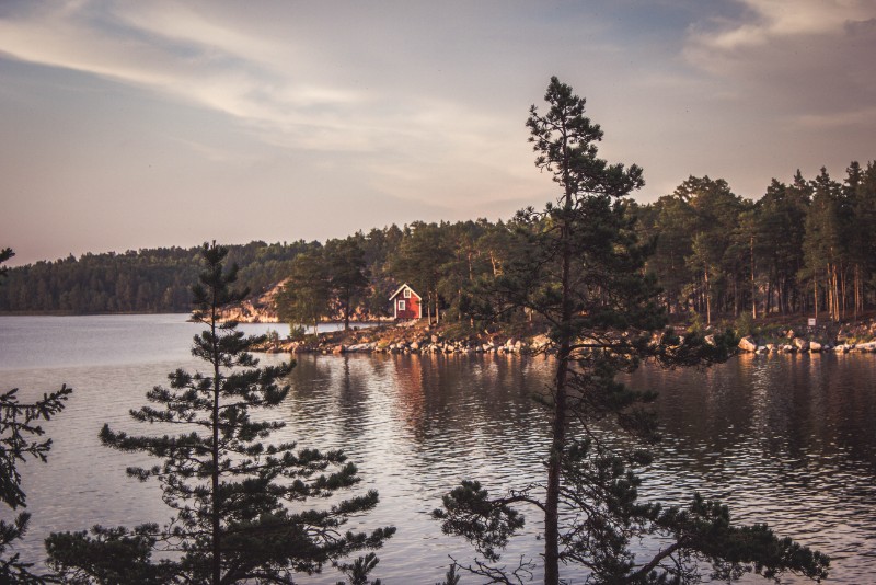 See mit roter Holzhütte in Schweden