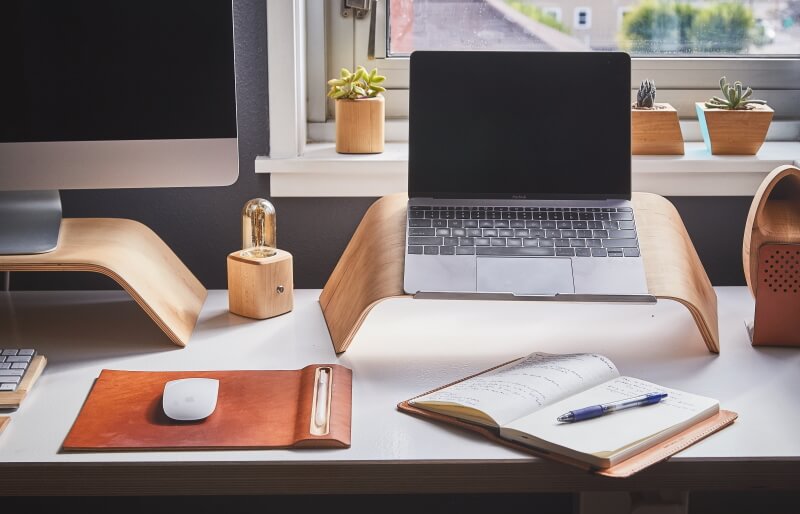 Schreibtisch mit Notebook auf Holzständer