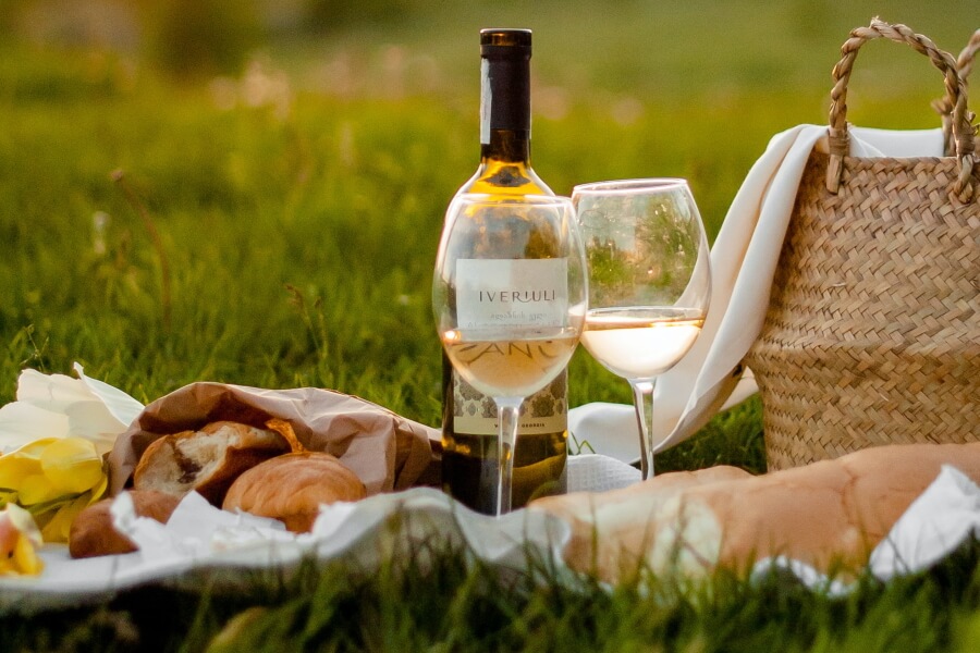 Picknickdecke auf Wiese mit Wein und Brot