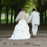 Hochzeitspaar schreitet auf Treppe im Park voran