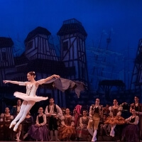Ballett Aufführung vor blauer Bühnen Kulisse mit Stadtbild
