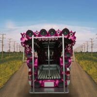 Musik Truck mit pinken Lautsprechern auf Landstraße
