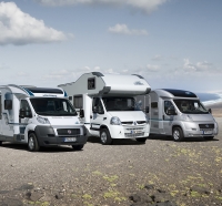 drei wohnmobile auf schotterparkplatz